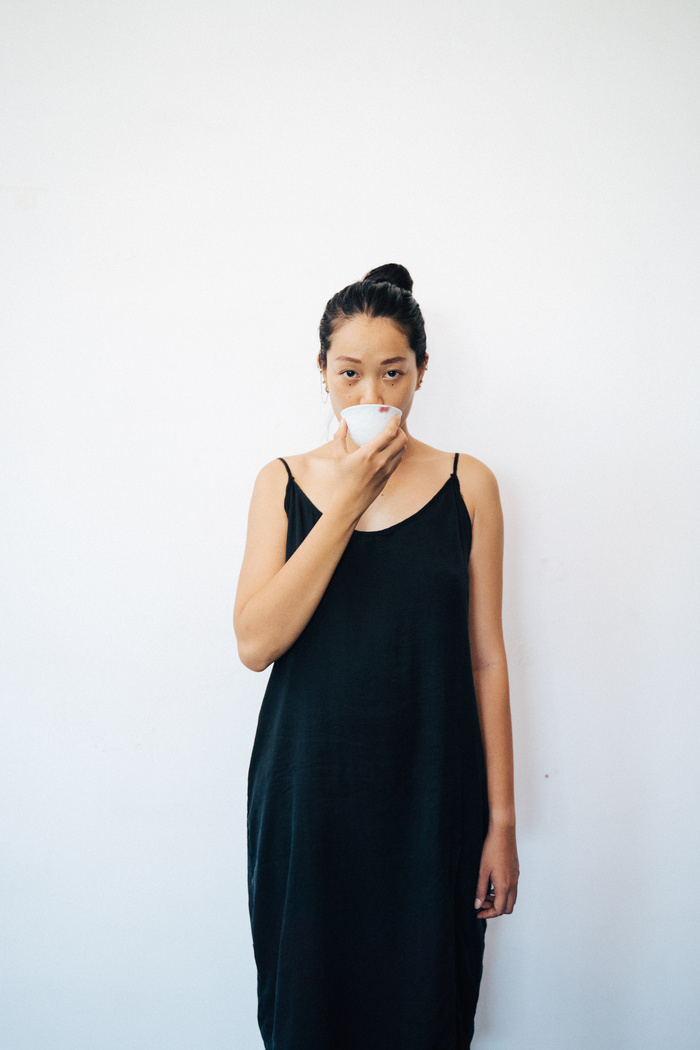 Woman in Black Dress Holding a Cup